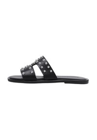 Chanclas negras de slide con dos tiras anchas adornadas con tachuelas plateadas. Suela plana, hecha de material suave, diseño minimalista.