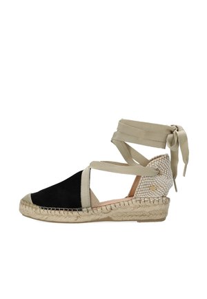 Zwarte suède espadrille sleehak met beige canvas enkelbandjes en een gevlochten jutezool, voorzien van een getextureerde hakdetail en ronde accenten.