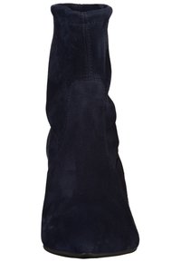 Bottine en daim marine avec un design ajusté, texture lisse et détails de couture subtils, présentant un bout arrondi et une semelle en caoutchouc basse.