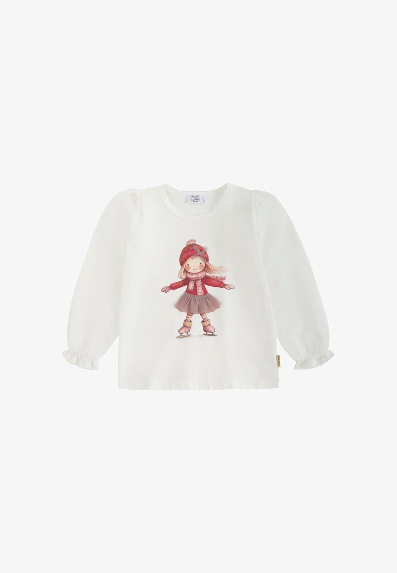 Camicia bianca a maniche lunghe con polsini arricciati, caratterizzata da una grafica frontale di una ragazza con un cappello e una sciarpa rossi, che indossa una gonna e pattini da ghiaccio.