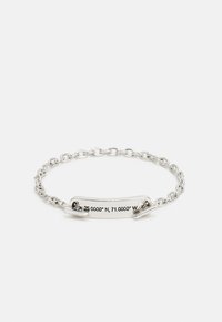 Pulseira de prata com um design de corrente e uma placa curva inscrita com as coordenadas "25.0000° N, 71.0000° W." Acabamento em metal suave.