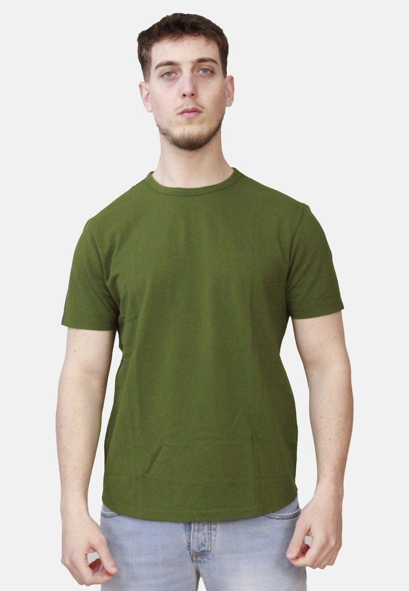 T-shirt in cotone verde oliva con maniche corte e scollatura rotonda, caratterizzata da un logo discreto sulla parte sinistra del petto. Design semplice e aderente.
