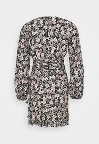 Robe fleurie à manches longues bouffantes, avec un fond noir et des fleurs rose clair et blanches. Taille froncée et ourlet à volants.