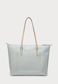 Bolsa de tote azul clara feita de tecido durável com uma textura suave. Apresenta duas alças em couro castanho e um bolso frontal com detalhes em costura.
