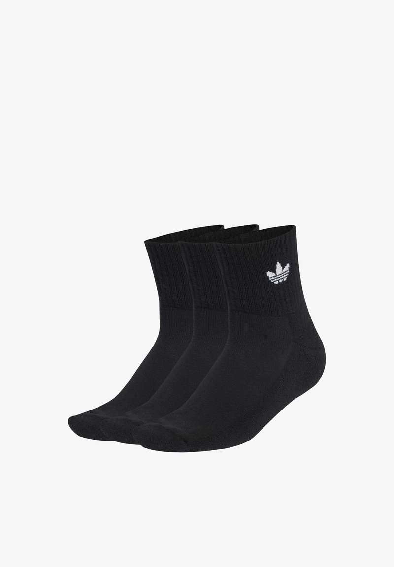 Trois chaussettes montantes noires avec des bord-côtes et un logo Adidas trefoil blanc à la cheville, disposées côte à côte sur un fond blanc.