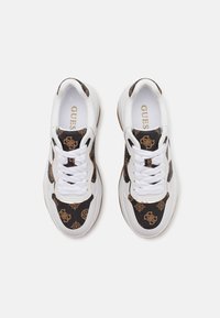 Sneakers featuring a white leather base with a brown and black patterned fabric upper, lace-up design, and prominent logo detailing.