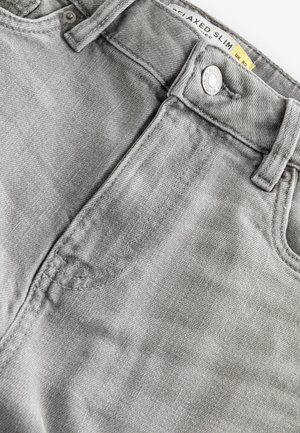 Grå denim jeans med en afslappet slim fit. Har en topknaplukning, metalnitter og en subtil tekstur. Mærket er synligt ved taljen.