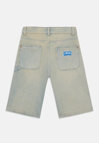 Shorts en denim bleu clair avec une coupe droite, dotés de poches arrière et d'une étiquette bleue "Vingino" sur la poche droite.