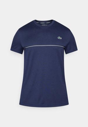 Maglietta a maniche corte blu navy con scollo rotondo, caratterizzata da una striscia orizzontale bianca e un logo di coccodrillo verde sul petto a sinistra.