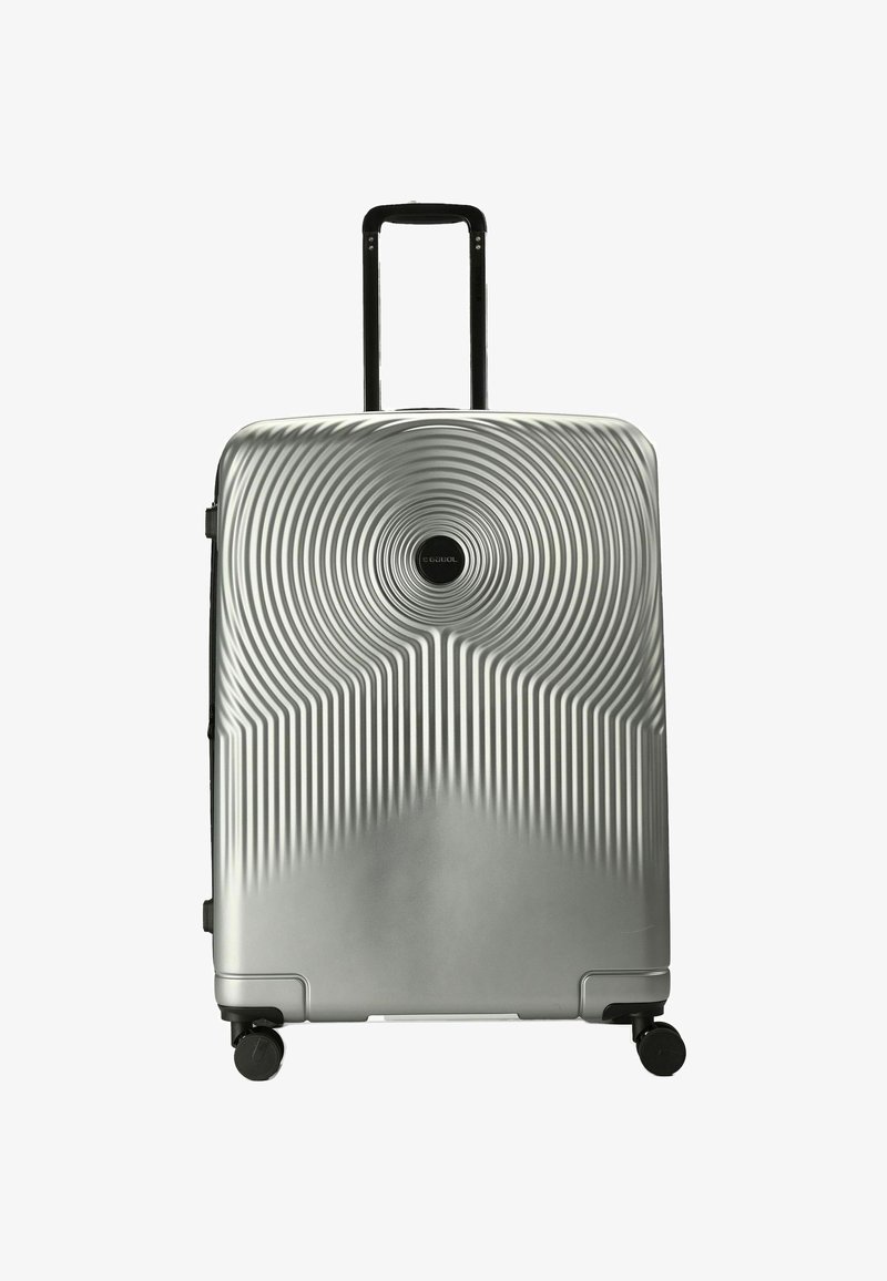 Valigia rigida silver con design a cerchi concentrici e strisce verticali, maniglia telescopica estesa e quattro ruote girevoli nere.