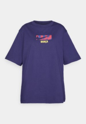 Fialová krátkorpová tričko s grafickou potlačou červenej a modrej Nike swoosh a textom "BARÇA" v žltom pod ňou na hrudi.