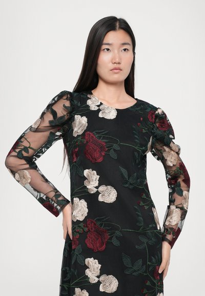 Zwarte jurk met doorschijnende lange mouwen, voorzien van ingewikkelde bloemdecoraties in rood, crème en groen, met een ronde halslijn en een getailleerde pasvorm.