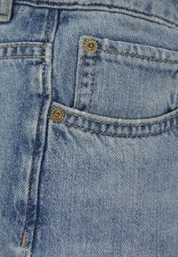 Ljusblå denimjeans med synlig sömnad och metallhardware på framfickan. Lätt använd textur förstärker det visuella detaljerna.