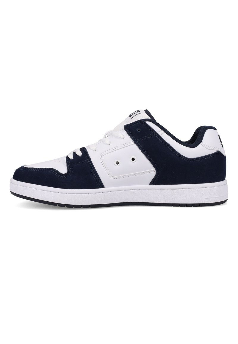 Sneakers featuring a white leather upper with navy suede accents, a padded collar, lace-up design, and a textured rubber sole.
