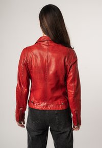 Veste en cuir rouge avec un col structuré, un design ajusté et des poignets zippés. Sa texture lisse et ses coutures visibles accentuent son style.