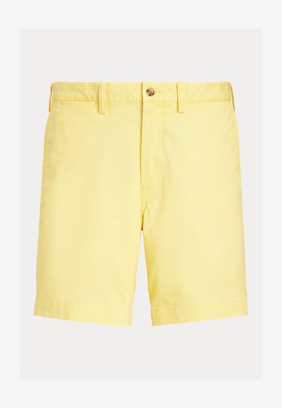 Žlté bavlnené šortky s gombíkovým zapínaním, jedným predným vreckom a natáčacím lemom. Hladká textúra, rovný strih a ležérny dizajn.