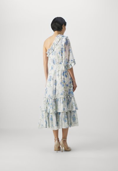 Bloemendess met één schouder, gerimpelde accenten en een gelaagde rok. Lichtgewicht stof in wit met blauwe bloemen en groene bladeren.
