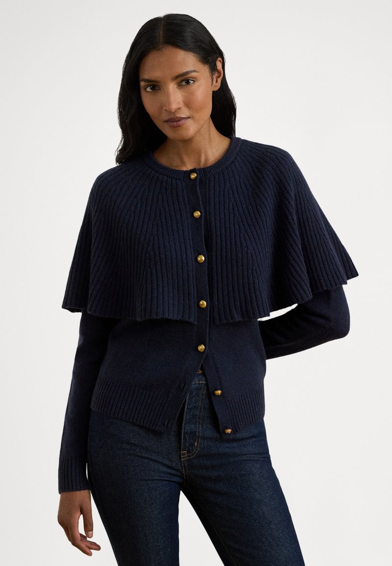 Meresinine soonikkoes kardigan kihilise kapuutsiga, millel on kuldsed nupud ja tekstuuriga viimistlus. Pehme kangas ja istuv siluett.