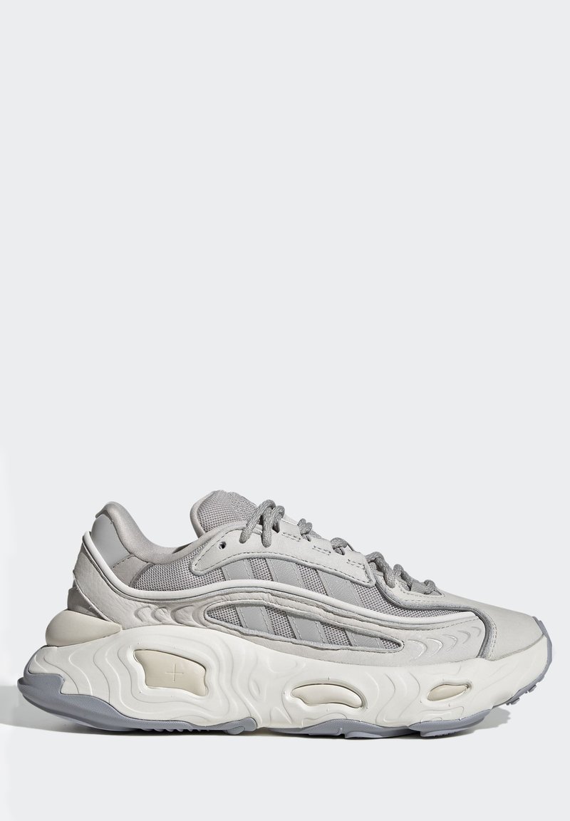 Graue Sportschuhe mit einem Obermaterial aus Mesh und Synthetik, strukturiertem Profil, gepolstertem Schaft und hervorgehobenen Akzenten. Verfügt über Logostreifen an der Seite.