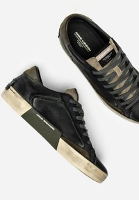 Sneaker in pelle nera con accenti in suede grigio e oliva, dotati di suola in gomma, lacci testurizzati e soletta con marchio.