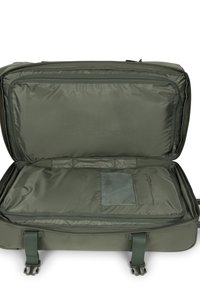 Valise en nylon balistique vert avec une ouverture zippée, dotée d'un intérieur spacieux, d'une poche en filet et de poignées renforcées. Aucun matériel visible.