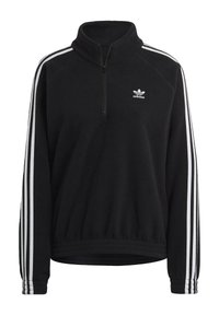 Černý fleecový pulovr se čtvrtinovým zipem, s bílými třípruhovými akcenty na rukávech a malým bílým logem Adidas na hrudi. Měkká textura.