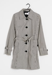 Trench-coat à rayures noires et blanches avec col, six boutons noirs, deux poches avant et taille ceinturée. Tissu texturé avec des accents contrastants.