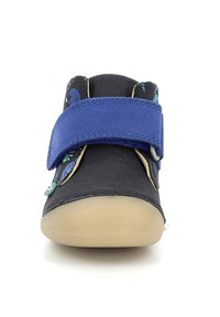 Schwarzer und blauer Kinderschuh mit einem Klettverschluss, runder Zehenpartie und einer profilierten Gummisohle. Mit verspielten Designs auf dem Obermaterial.