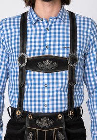 Blue and white checked shirt with a black lederhosen. Black leather straps with silver hardware and embroidered details on the chest area.