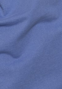 Tejido ribeteado azul con textura suave, que muestra reflectancia de luz y patrones de ondas sutiles a lo largo del material.