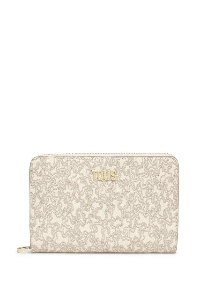Billetera beige con un patrón texturizado y ondulado, con letras en tono dorado "TOUS". Cierre de cremallera y material de tela. Forma rectangular compacta.