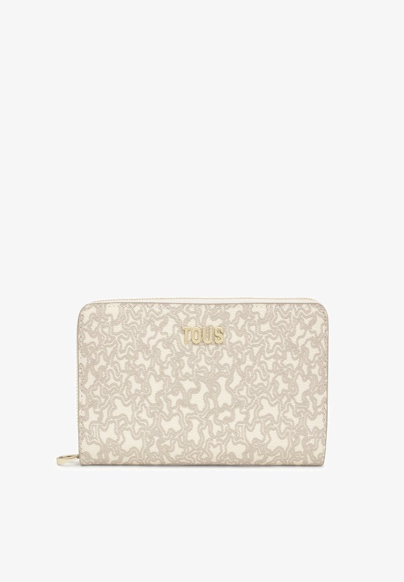 Billetera beige con un patrón texturizado y ondulado, con letras en tono dorado "TOUS". Cierre de cremallera y material de tela. Forma rectangular compacta.