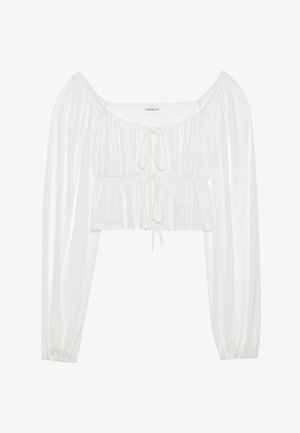 Blouse blanche courte avec de longues manches bouffantes. Dotée d'un devant froncé et d'un détail à cordon au niveau du col. Tissu lisse et léger.