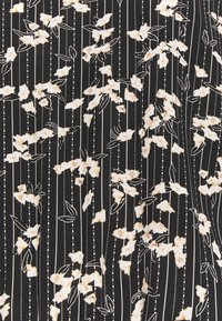 Tissu noir à lignes blanches verticales orné de petites fleurs blanches dispersées avec des accents jaunes et des feuilles vertes.