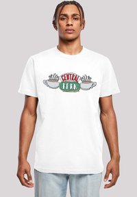 White cotton t-shirt featuring "CENTRAL PERK" logo in red and green, with coffee cups and steam illustrations. Short sleeves, relaxed fit.