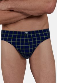 Marineblaue Herrenunterhosen mit einem grünen und gelben Karomuster. Weicher Stoff, elastischer Bund mit kleinem Logo. Figurschmeichelndes Design.