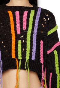Pull en laine noir à manches courtes avec des rayures verticales multicolores en orange, rose, vert et violet, avec des finitions à franges et un design ajouré.