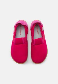 Różowe buty wsuwane z kanwy, z elastycznymi wstawkami i gumowymi podeszwami. Posiadają miękką, kontrastującą różową sekcję na pięcie.