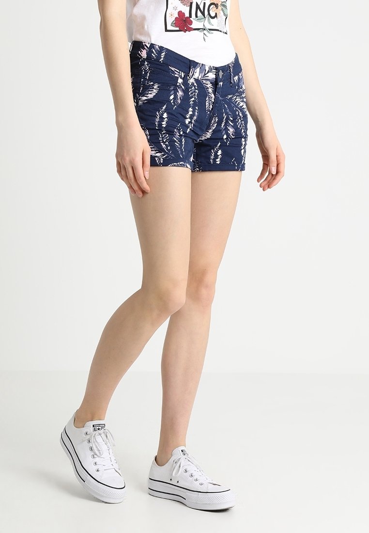 Krátné nohavice s květinovým vzorem v námořnické modré barvě, vyrobené z lehké tkaniny s přiléhavým střihem, vybavené předními kapsami a zapínáním na zip.