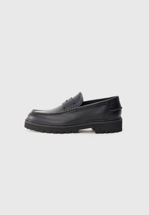 Sorte lærloafers med en stitch-øvre, gummisåle og minimalistisk design. Har en glat tekstur og slip-on stil.