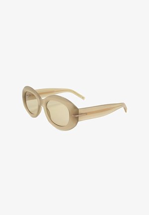 Occhiali da sole rotondi beige con montatura spessa traslucida e lenti colorate abbinate, mostrati inclinati di lato su sfondo bianco.