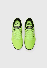 Zapatillas deportivas de color verde neón con un upper texturizado, detalles en negro y un collar acolchado. Incluyen cordones planos y un logo en la lengüeta.