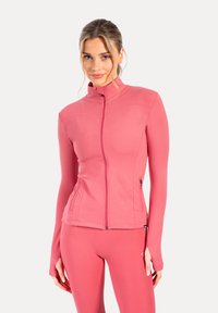 Chaqueta rosa ajustada con cremallera y alto cuello, de textura suave y con bolsillos laterales. Mangas largas con agujeros para los pulgares para mayor funcionalidad.