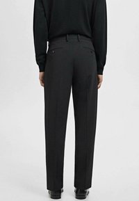 Pantalons noirs sur mesure à coupe droite, dotés de passants de ceinture et de poches arrière. Texture de tissu lisse, design épuré et sans motifs visibles.