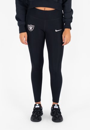 Czarne legginsy z logo Oakland Raiders i białym znakiem Nike. Elastyczny materiał z dopasowanym krojem, w połączeniu z czarnymi sneakersami.