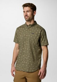 Camicia verde oliva a maniche corte con colletto button-down, caratterizzata da un motivo di piccole illustrazioni a tema deserto e una tasca sul petto.