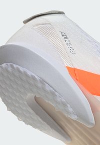 Scarpa da ginnastica bianca con tomaia strutturata, caratterizzata da un vivace accento arancione e una suola di gomma con grip a motivo. "ADIZERO" è impresso.