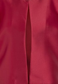 Röd blus med en mjuk, glänsande yta och en central sprund fram. Materialet är lätt och något strukturerat.