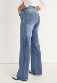 Ljusblå, vida jeans i denim med två bakfickor och hög midja, med en slät yta och en ren finish.