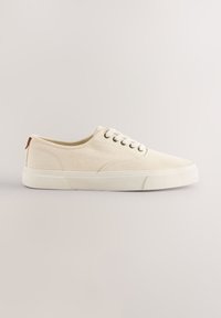 Smėlio spalvos drobiniai sportbačiai žemu viršumi, apvalia nosimi, šešių akių raišteliais ir balta gumine padu. Subtilūs siūlai ir tekstūruotas paviršius.